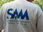 Blagajnikov hrbet je �irok - z uradno majico SAM-a.